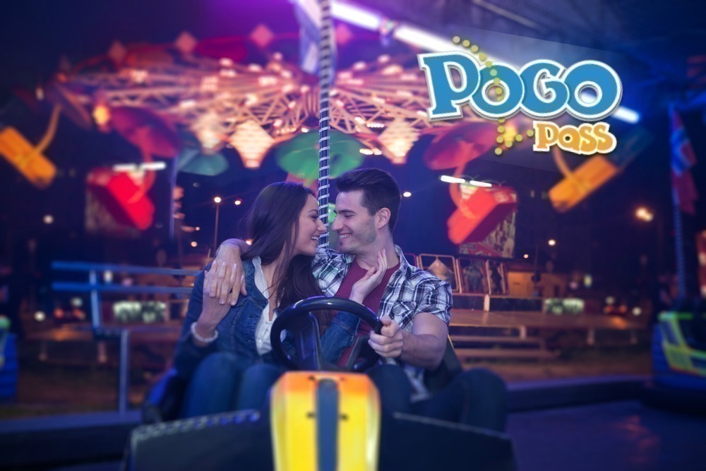 Affectionate couple sitting in bumper car at  amusement park