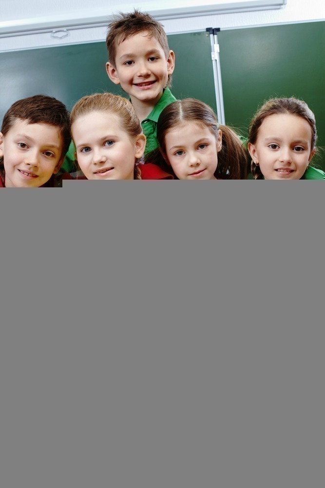 Portrait of happy children looking at camera in class