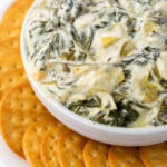 Slow Cooker Spinach Artichoke Dip is always a favorite at parties and get togethers. Make it with just a few simple ingredients in your slow cooker or crockpot for an easy way to feed a crowd.