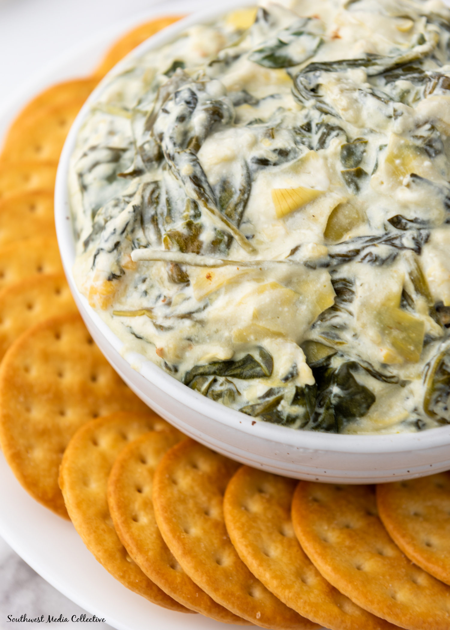 Slow Cooker Spinach Artichoke Dip is always a favorite at parties and get togethers. Make it with just a few simple ingredients in your slow cooker or crockpot for an easy way to feed a crowd.