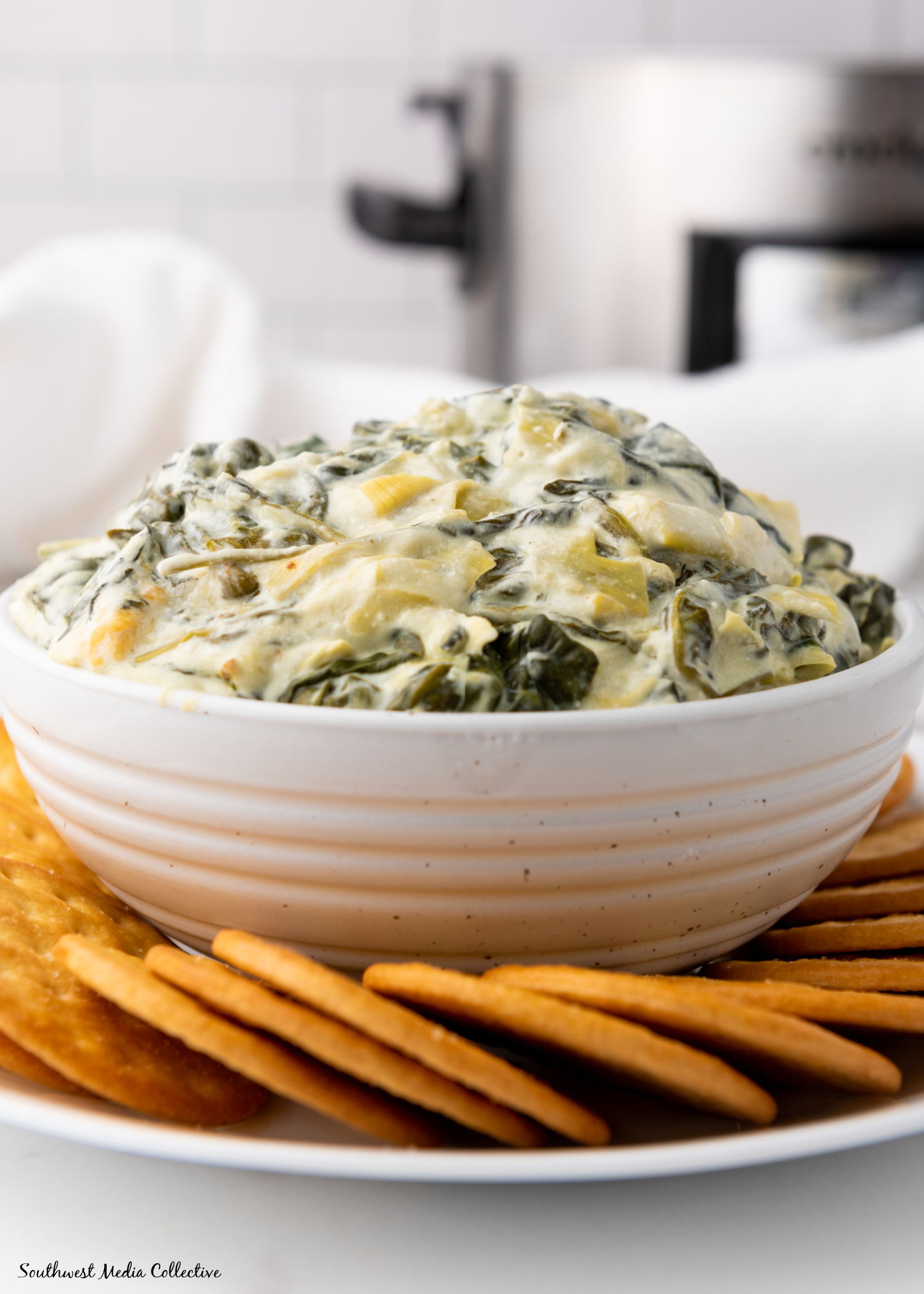 Slow Cooker Spinach Artichoke Dip is always a favorite at parties and get togethers. Make it with just a few simple ingredients in your slow cooker or crockpot for an easy way to feed a crowd.